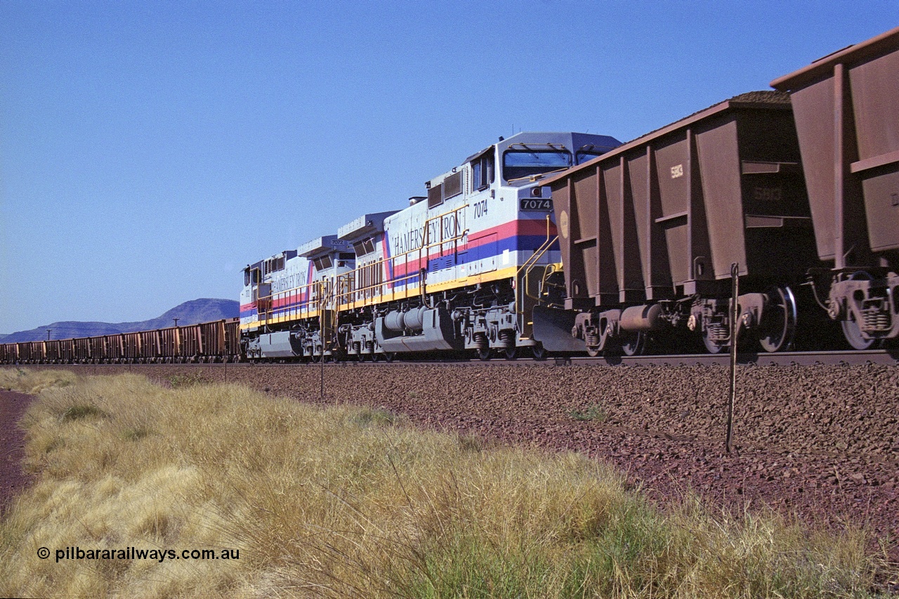 250-13
Pelican Siding on the Hamersley Iron Tom Price line about the 208 km with an empty train behind General Electric built 9-44CW units 7068 serial 47747 and 7067 serial 47746 on the loop as a loaded train with 210 waggons passes behind a sister pairing of 7072 serial 47751 and 7074 serial 47753. 1550 hrs 21st October 2000.
Keywords: 7074;GE;Dash-9-44CW;47753;