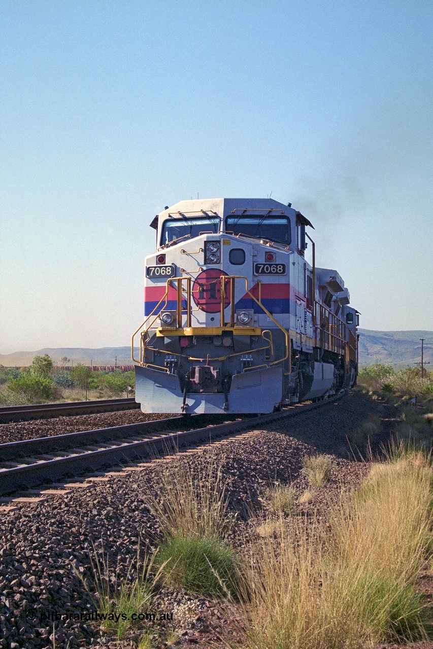 250-17
Pelican Siding on the Hamersley Iron Tom Price line about the 208 km with an empty train behind the standard pairing of two General Electric built 9-44CW units 7068 serial 47747 and 7067 serial 47746 stand on the loop or passing track for a meet with a loaded train. 1550 hrs 21st October 2000.
Keywords: 7068;GE;Dash-9-44CW;47747;