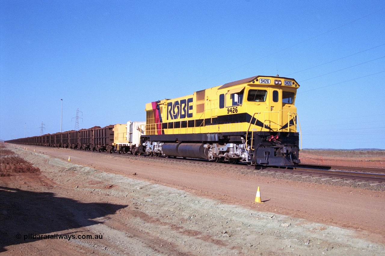 250-24
Cape Lambert South Yard and Robe River's 9426 a Comeng WA rebuild from ALCo Schenectady NY model C636 serial 3499-3 originally built in January 1968 for Pennsylvania as #6332, Penn Central 6332 and finally Conrail 6782. Purchased in 1986 and rebuilt by Comeng WA into C636R before delivery to Robe in November 1986. This loco also went on to become DR 8401 for construction of FMG's railway in 2007-08. Seen here in the South Yard dragging a loaded rake down to the car dumper as yard expansion works are underway to the left. 22nd October 2000.
Keywords: 9426;Comeng-WA;C636R;WA143-1;rebuild;ALCo;Schenectady-NY;C636;Conrail;6782;3499-3;