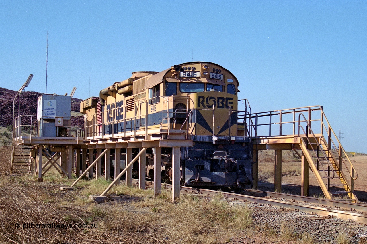 250-30
Cape Lambert yard in the Load Box is recently stored Robe River AE Goodwin built ALCo M636 unit 9415 serial G6060-6 from February 1973 and was an extension of the original order and delivered with cab side numbering of 86-14-1715 and number boards as 1715. The ducting on the hood is the air to air intercooler modifications. 22nd October 2000.
Keywords: 9415;AE-Goodwin;ALCo;M636;G6060-6;