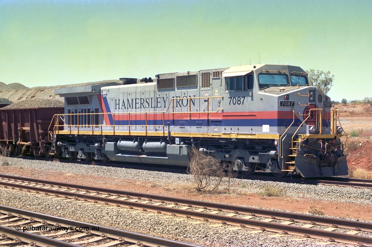 252-15
Cockatoo Siding 273 km on the Hamersley Iron line to Yandi, General Electric built 9-44CW unit 7087 with serial number 47766 from the original 1994 build idles away on the western end of the ballast train as it is loaded and slowly progresses into the back track siding Ballast plough BP 01 is behind the locomotive. Location is roughly [url=https://goo.gl/maps/rNdCHRcDhbQuHTjd7]here[/url]. 24th November 2001.
Keywords: 7087;GE;Dash-9-44CW;47766;