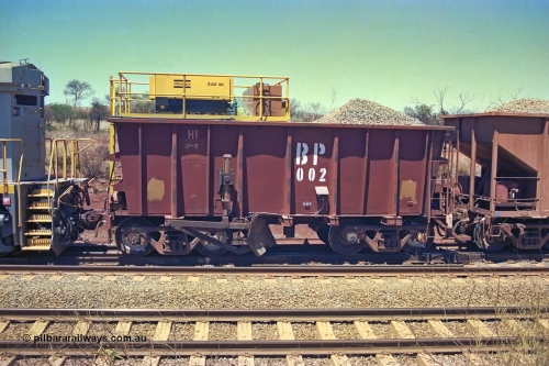 252-02
Cockatoo Siding 273 km on the Hamersley Iron line to Yandi, ballast plough waggon BP 02 is on the end of a ballast rake being loaded. BP 02 has been converted from an Nippon Sharyo ore waggon with the mounting of an air compressor on top and the fitting of a plough blade, the waggon is also loaded with ballast to ballast the plough. Location is roughly [url=https://goo.gl/maps/gNdgoAj6uJoYb2q36]here[/url]. 24th November 2001.
Keywords: BP-type;BP02;Rio-ballast-plough;Nippon-Sharyo;