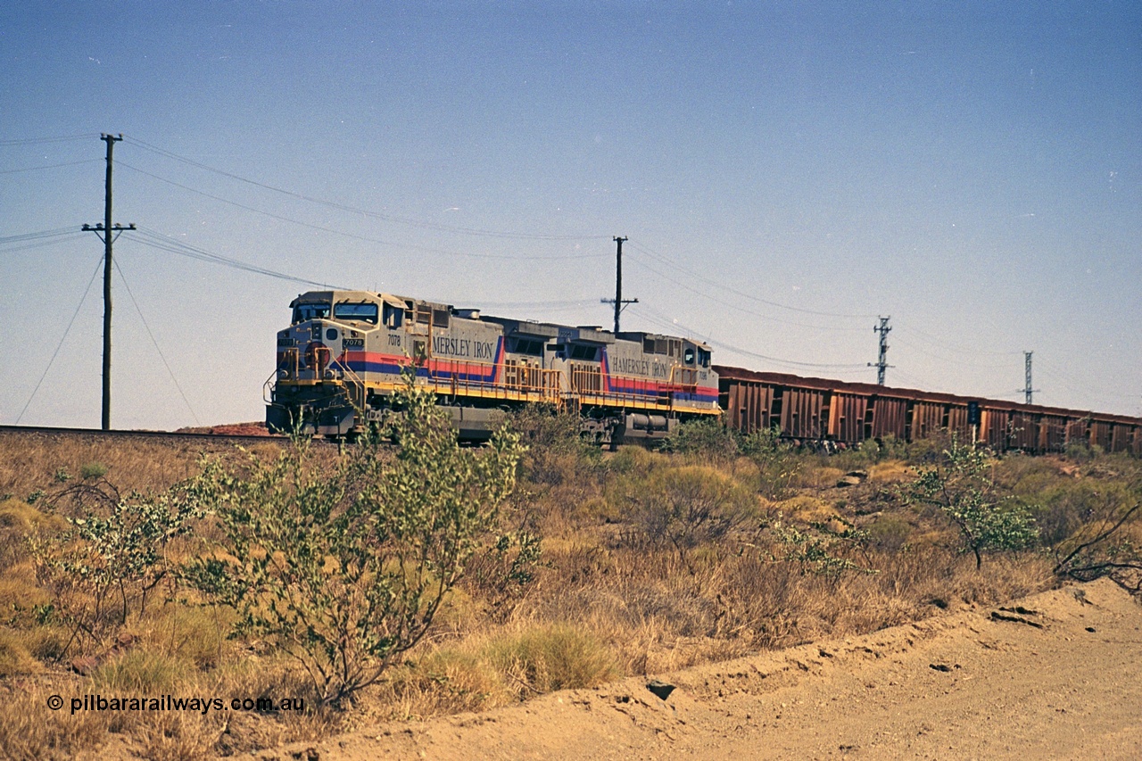 253-03
Dugite near the 64 km on the Dampier - Tom Price railway, a loaded Hamersley Iron train headed up by General Electric 9-44CW units 7078, from the original order, serial number 47757 and 7096, from the second order, serial number 52843 arrive taking the mainline to cross an empty which is in the passing track.
Keywords: 7078;GE;Dash-9-44CW;47757;