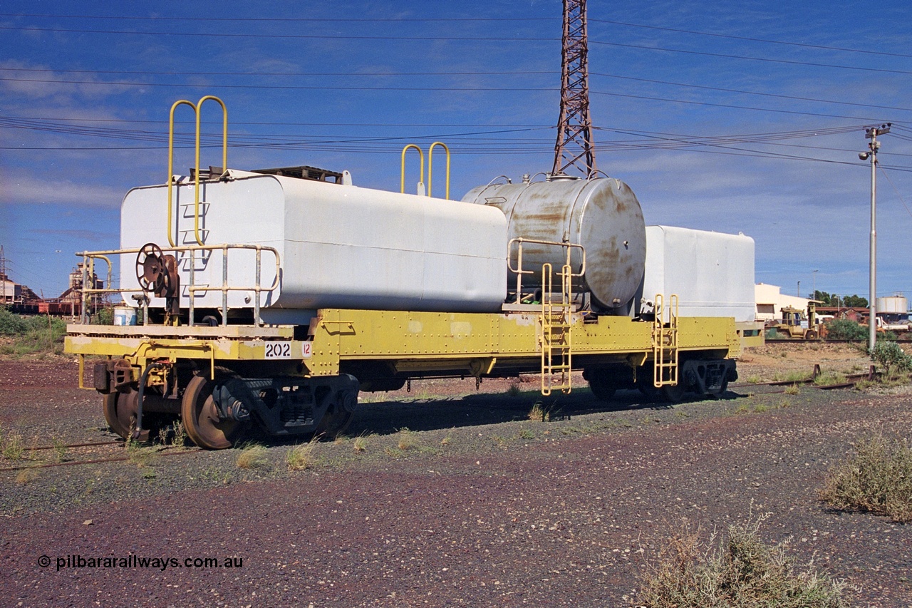 253-34
Nelson Point hard stand area, riveted flat waggon 202 with three water tanks fitted, view of handbrake end, originally part of the 'camp train', modified by Mt Newman Mining railway workshops.
Keywords: BHP-flat-waggon;