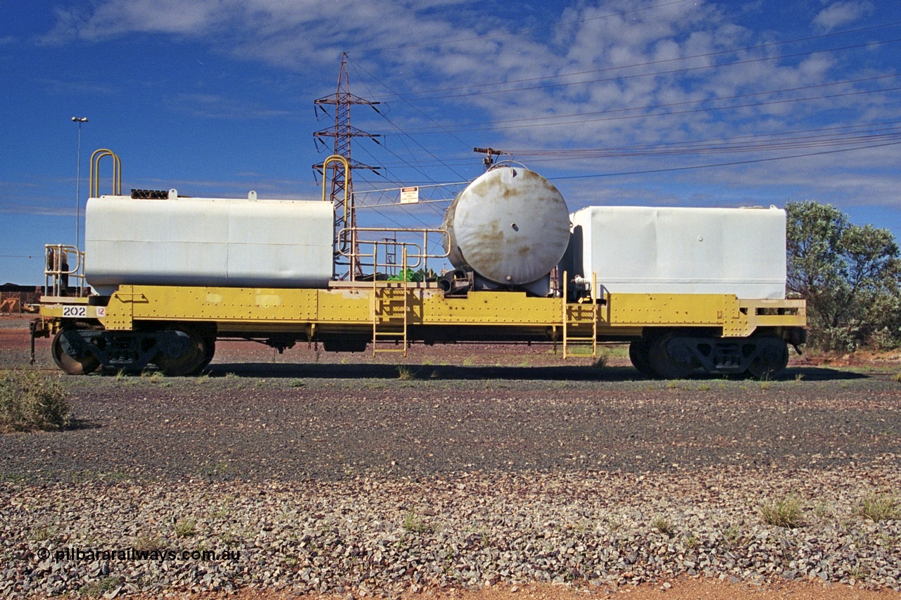 253-35
Nelson Point hard stand area, riveted flat waggon 202 with three water tanks fitted, side profile view, originally part of the 'camp train', modified by Mt Newman Mining railway workshops.
Keywords: BHP-flat-waggon;