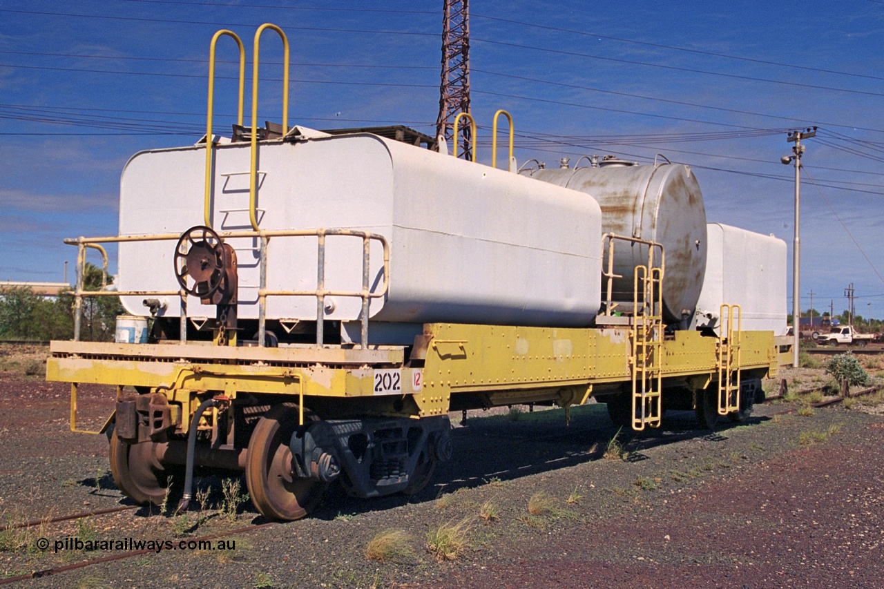 253-36
Nelson Point hard stand area, riveted flat waggon 202 with three water tanks fitted, view of handbrake end, originally part of the 'camp train', modified by Mt Newman Mining railway workshops.
Keywords: BHP-flat-waggon;