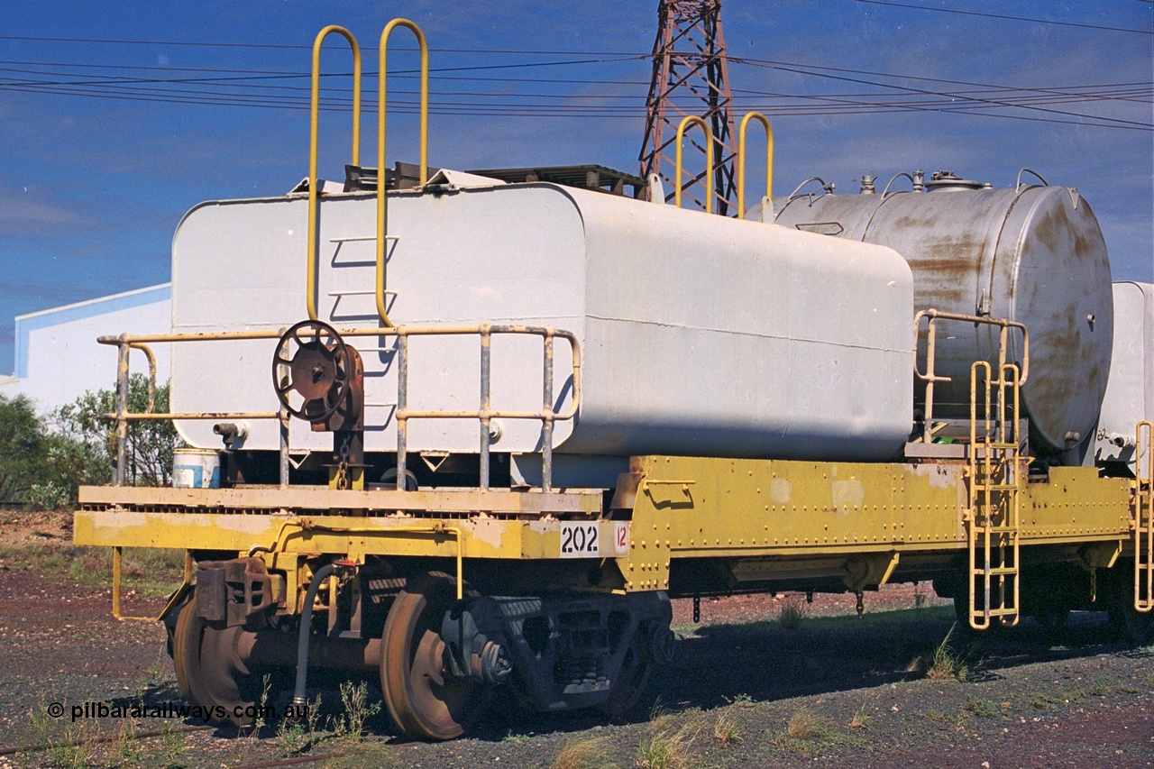253-37
Nelson Point hard stand area, riveted flat waggon 202 with three water tanks fitted, view of handbrake end, originally part of the 'camp train', modified by Mt Newman Mining railway workshops.
Keywords: BHP-flat-waggon;