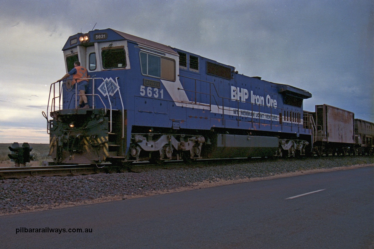 254-14
Boodarie, BHP empty train arrives back at the yard following unloading at Finucane Island behind Goninan built CM39-8 locomotive 5631 'Apollo' serial number 5831-10 / 88-080. The second man is getting out to operate the points. September 2001.
Keywords: 5631;Goninan;GE;CM39-8;5831-10/88-080;