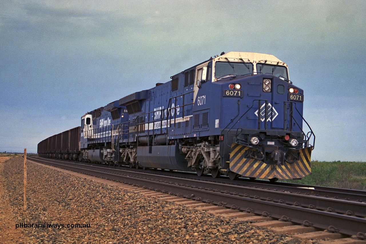 254-21
Bing Siding, an empty train awaits departure time behind 6071 an General Electric built AC6000 model with serial number 51063. The locomotive has not yet been named. Second unit is Goninan rebuilt CM40-8MEFI locomotive 5668. September 2001.
Keywords: 6071;GE;AC6000;51063;