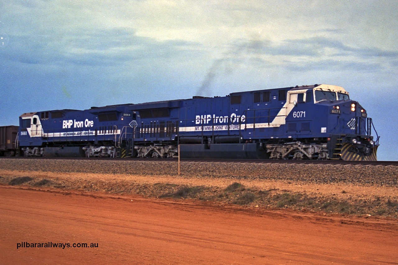 254-24
Bing Siding, an empty train departs behind 6071 an General Electric built AC6000 model with serial number 51063. The locomotive has not yet been named. Second unit is Goninan rebuilt CM40-8MEFI locomotive 5668. September 2001.
Keywords: 6071;GE;AC6000;51063;