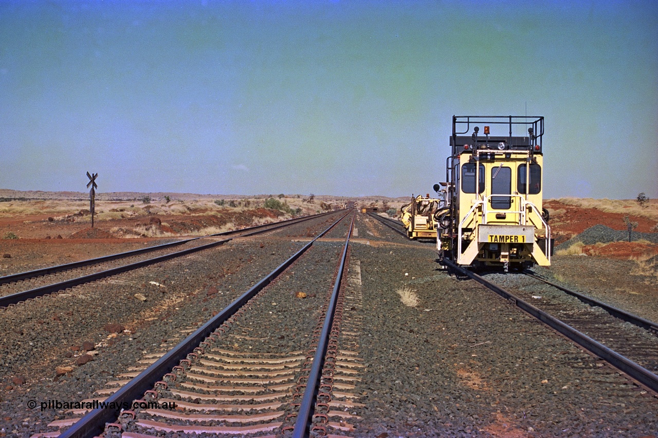 255-05
Siding Three looking south across the 133.3 km grade crossing with Tamper 1 and a sleeper inserter machine stabled in the back track. Both machines are Fairmont Tamper units. Geodata [url=https://goo.gl/maps/hn7S75CkAm2jmAuC9]location here[/url]. May 2002.
