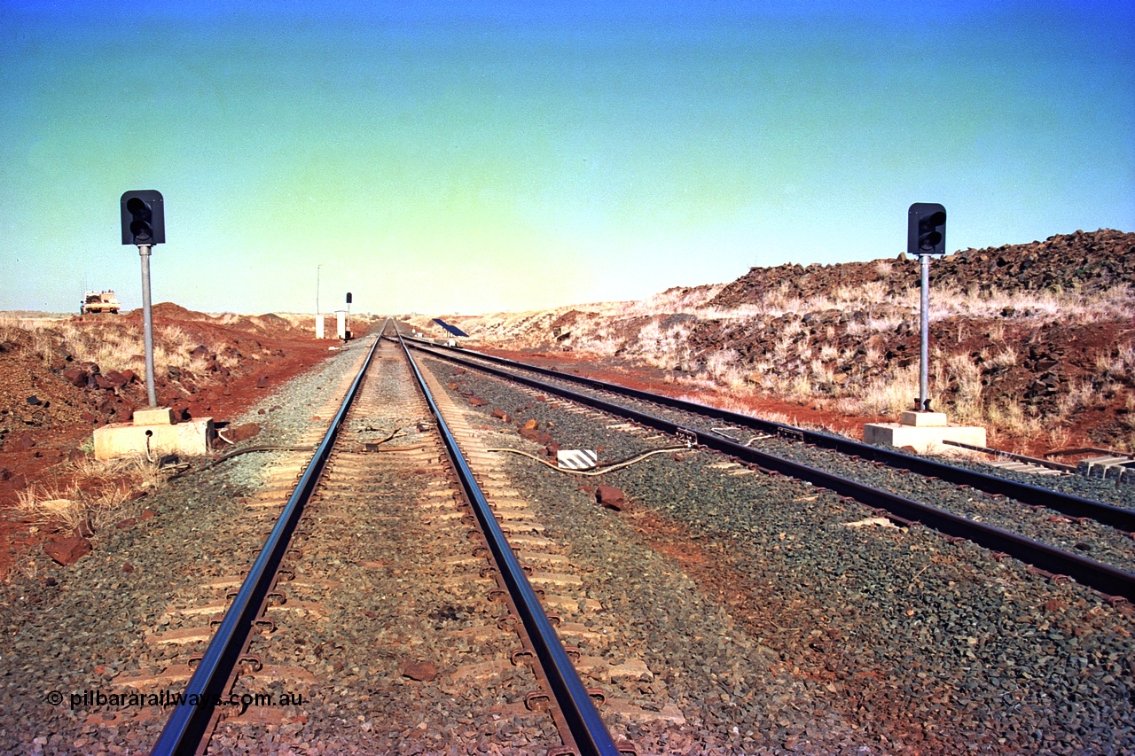 255-06
Siding Three looking south along the Cape Lambert to Deepdale mainline at the south end signals. Passing track is on the right. May 2002.
