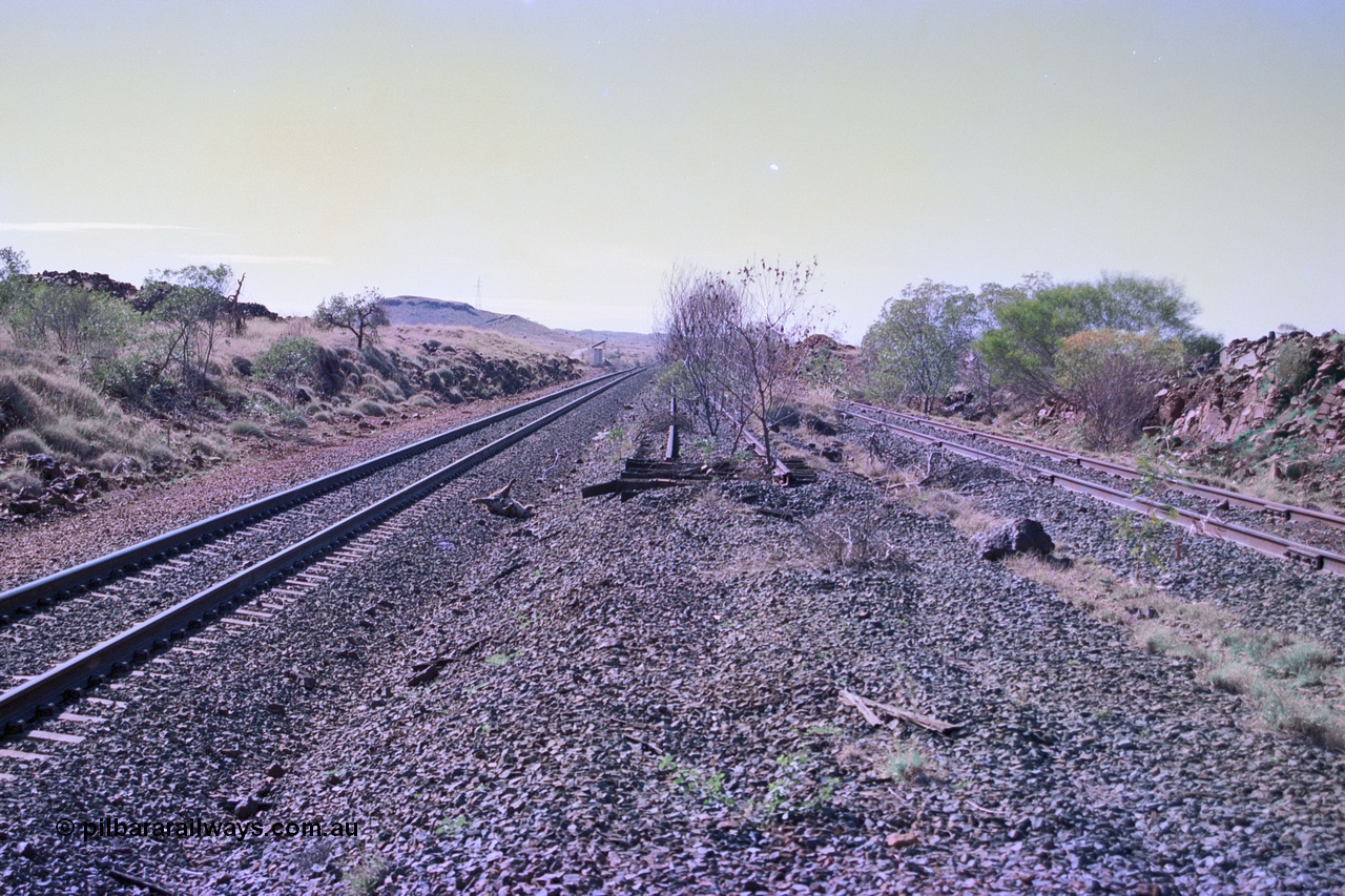 255-15
At the 162.2 km looking north are the remains of the second Robe River loadout facility which was installed in 1975 to mine the Mesa 2402E mining area, the line was a four kilometre U shaped spur. The Deepdale lone is on the left while the spur runs behind the photographer and curves away from the Deepdale line. Geodata [url=https://goo.gl/maps/DATgFuHfuayyAp8y9]location here[/url]. May 2002.
