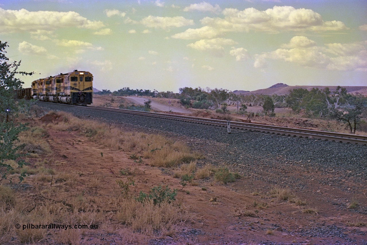 255-25
Western Creek at the 71 km on the Cape Lambert to Deepdale line an empty Robe River train powers upgrade as it heads to Mesa J for loading behind the standard quad CM40-8M lash up. Geodata [url=https://goo.gl/maps/fzacjsy5LHGwuSRg8]location here[/url]. May 2002.
