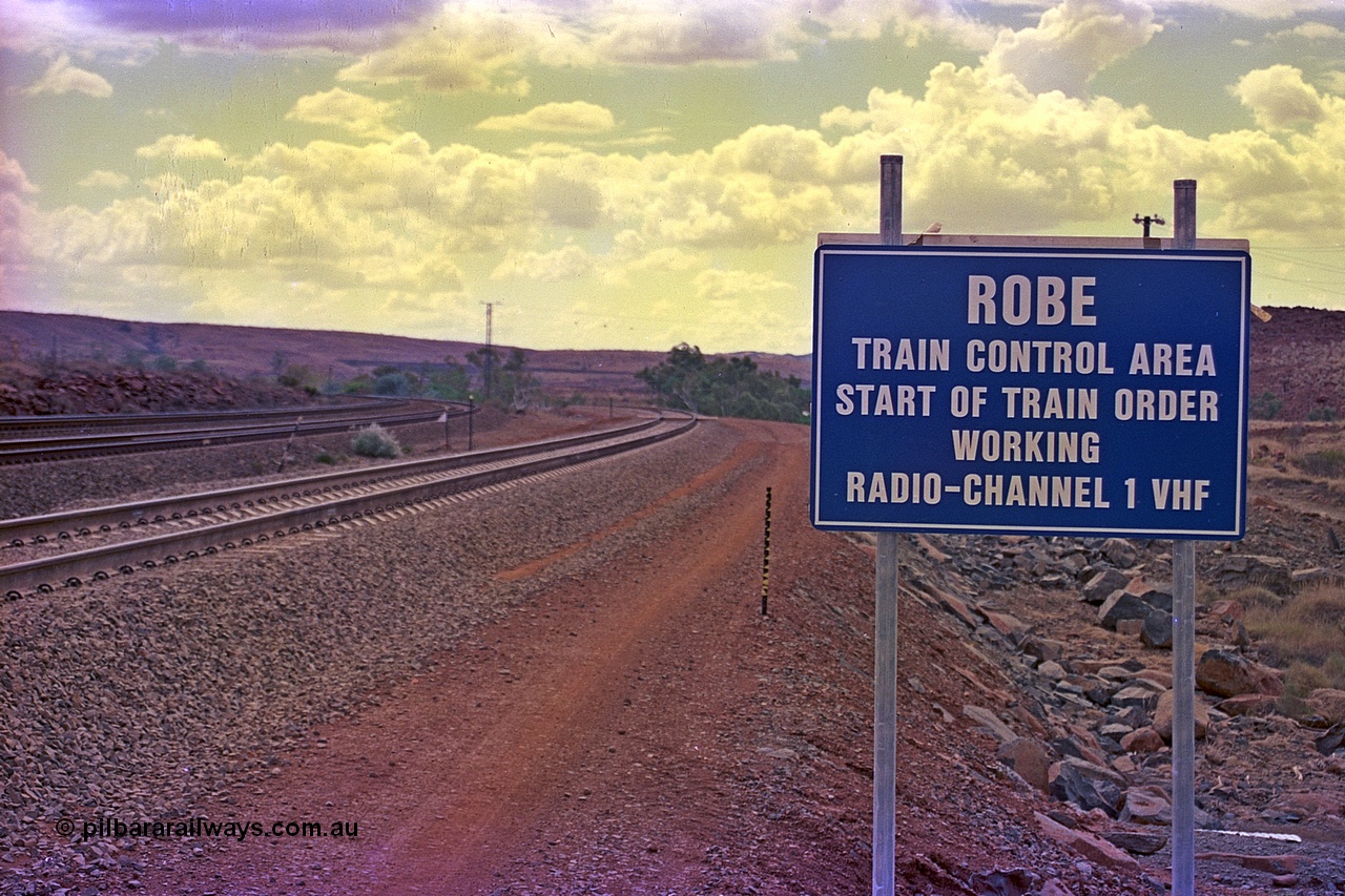 255-34
Emu Siding on the Hamersley Iron Dampier to Tom Price line with the Western Creek Robe River interconnecting line on the right heading around to join the Cape Lambert to Deepdale line. Train Control board for crews to change channels. May 2002.
