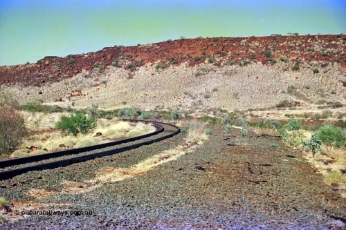 255-17
At the 162.2 km looking south are the remains of the second Robe River loadout facility which was installed in 1975 to mine the Mesa 2402E mining area, the line was a four kilometre U shaped spur curving away to the left. Geodata [url=https://goo.gl/maps/DATgFuHfuayyAp8y9]location here[/url]. May 2002.
