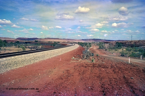255-24
Western Creek, looking south alongside the Robe River interconnecting line with the Western Creek bridge, on the right is the Hamersley Iron Dampier to Tom Price line. Geodata [url=https://goo.gl/maps/XKJRKgjAEhKLAzgu5]location here[/url]. May 2002.
