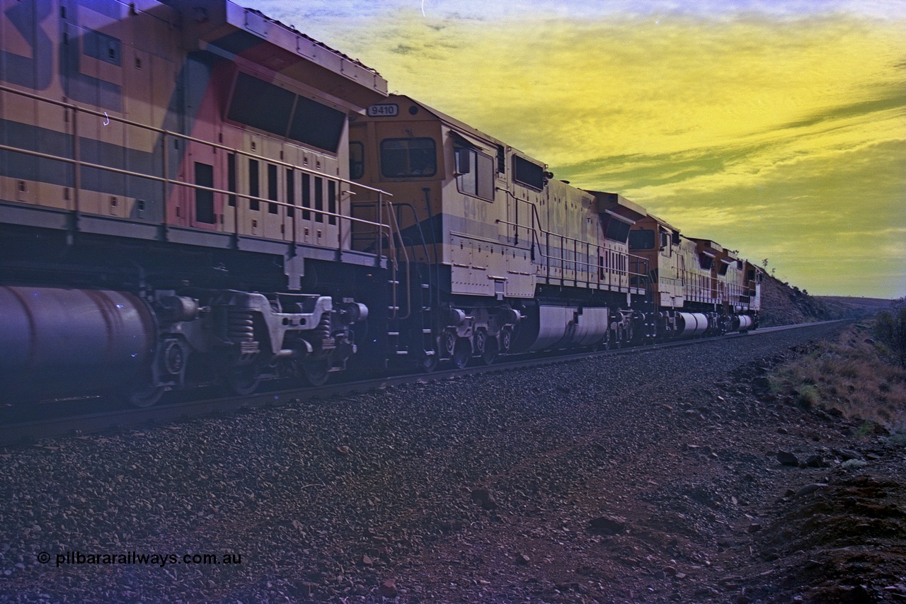 256-35
At the 89.6 km grade crossing the loaded train behind the quad CM40-8M working of 9414, 9420, 9410 and 9425 rolls across the crossing and heads down the 1.26 percent grade. 9410 (2nd) was built by Comeng NSW as an ALCo M636 model in November 1975 with serial number C6098-05 for Mount Neman Mining with road number 5500, it was sent to Goninan but not rebuilt. Eventually sold to Robe and rebuilt by Goninan WA to an CM40-8M model in March 1996 with serial number 2160-03/96-202. May 2002.
Keywords: 9410;Goninan;GE;CM40-8M;2160-03/96-202;rebuild;Comeng-NSW;ALCo;M636;C-6096-5;