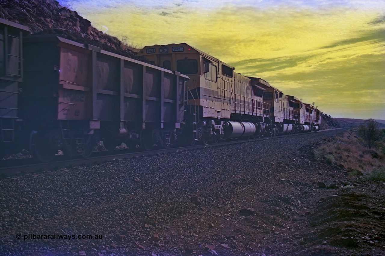 256-36
At the 89.6 km grade crossing the loaded train behind the quad CM40-8M working of 9414, 9420, 9410 and 9425 rolls across the crossing and heads down the 1.26 percent grade. 9425 was built by AE Goodwin NSW as an ALCo C636 in April 1970 with serial G-6041-4 for Mount Newman Mining with road number 5468. It was sold to Robe in August 1982 and repainted and renumbered to 9425. 9425 was rebuilt by Goninan WA in August 1989 to become an CM40-8M model with serial 6266-8 / 89-85. May 2002.
Keywords: 9425;Goninan;GE;CM40-8M;6266-8/89-85;rebuild;AE-Goodwin;ALCo;M636;G-6041-4;