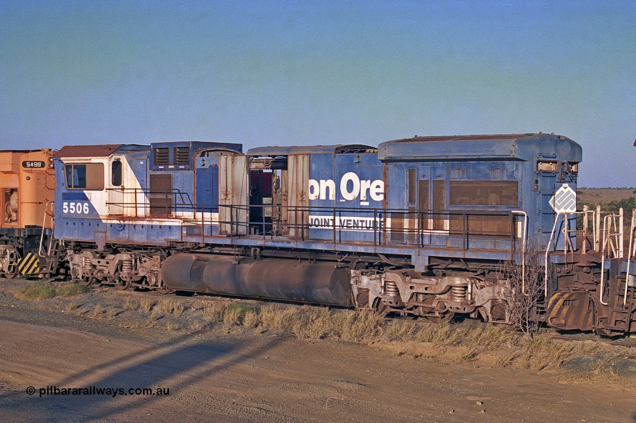 257-07
Flash Butt yard BHP's stored Goninan WA ALCo C636 to GE C36-7M rebuild unit 5506 awaits its fate. Rebuilt in 1987 at Goninan's Welshpool factory from a 1968 AE Goodwin built ALCo C636 with serial number G6012-4 and road number 5455 and assigned new serial number 4839-01 / 87-071. It was delivered in Mount Newman Mining orange and was named Mt Goldsworthy. 5506 was the first unit in the world where an ALCo C636 had been rebuilt into an GE C36-7. Late 2001.
Keywords: 5506;Goninan;GE;C36-7M;4839-01/87-071;rebuild;AE-Goodwin;ALCo;C636;5455;G6012-4;