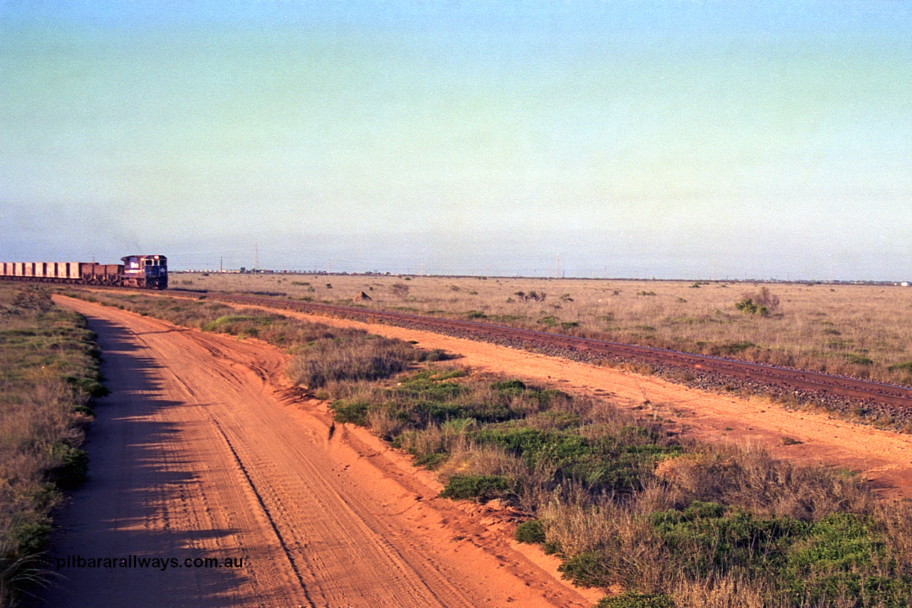 257-23
Goldsworthy Junction, an empty train runs between the junction and the Broome Rd crossing behind the standard single locomotive 5646 'White Springs', a Goninan 1992 built GE CM40-8 model with serial number 5244-11 / 92-135. Late 2001.
Keywords: 5646;Goninan;GE;CM40-8;8244-11/92-135;