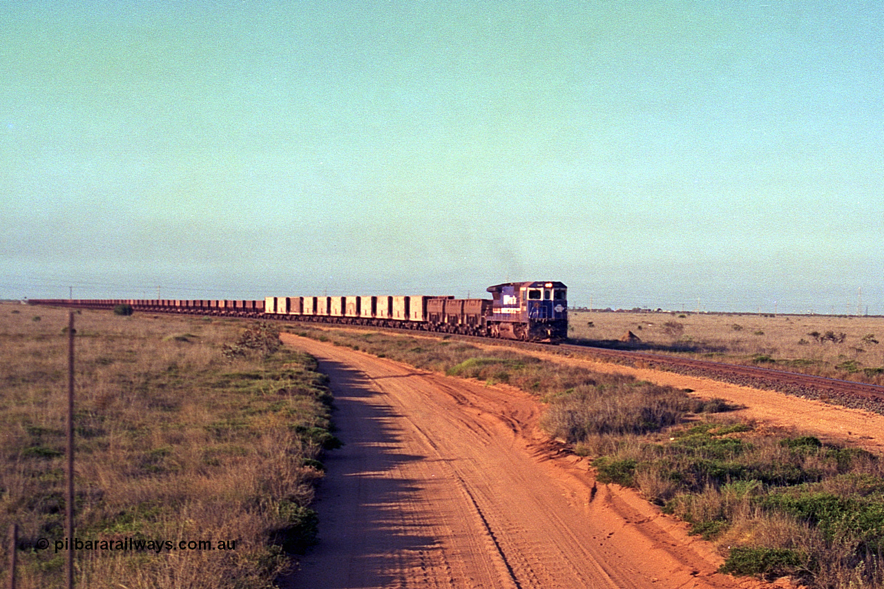 257-24
Goldsworthy Junction, an empty train runs between the junction and the Broome Rd crossing behind the standard single locomotive 5646 'White Springs', a Goninan 1992 built GE CM40-8 model with serial number 5244-11 / 92-135. Late 2001.
Keywords: 5646;Goninan;GE;CM40-8;8244-11/92-135;