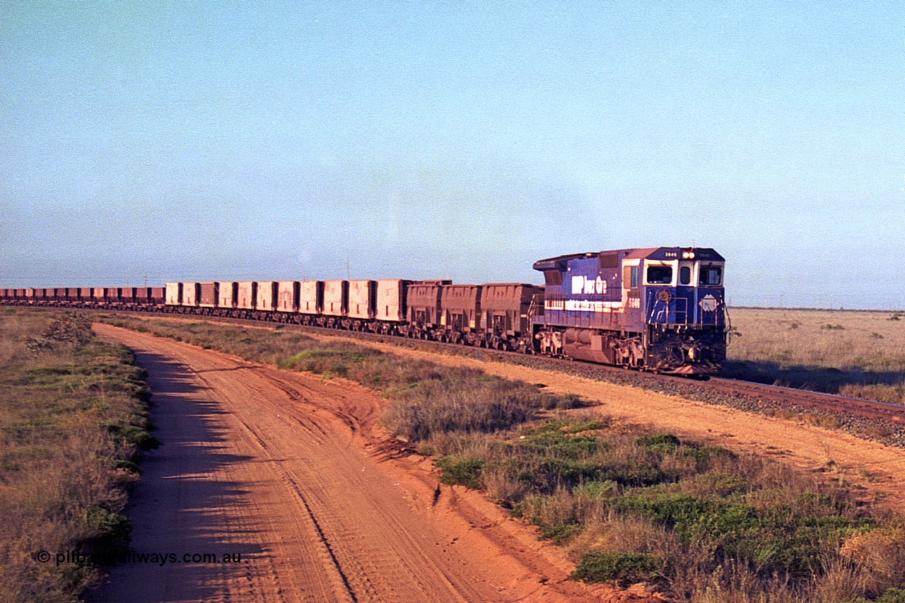 257-25
Goldsworthy Junction, an empty train runs between the junction and the Broome Rd crossing behind the standard single locomotive 5646 'White Springs', a Goninan 1992 built GE CM40-8 model with serial number 5244-11 / 92-135. The four styles of waggon in use are visible, behind the loco are three Golynx waggons, then a number of Gunderson USA builds, the ribbed type is a Portec USA built and then following are the Tomlinson WA and Scotts of Ipswich built 70 ton waggons. Late 2001.
Keywords: 5646;Goninan;GE;CM40-8;8244-11/92-135;