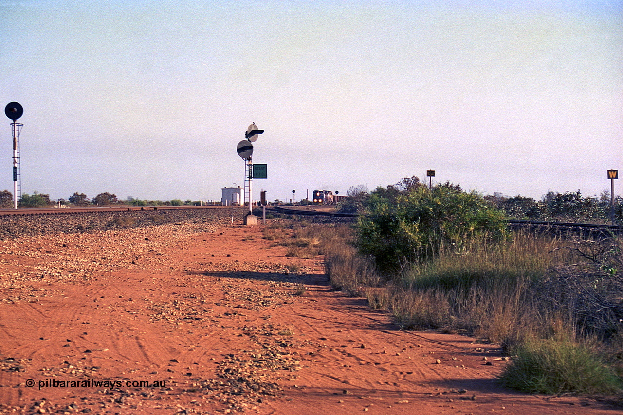 257-28
Goldsworthy Junction looking north as an empty train approaches, the line curving in from the right in the Goldsworthy or Yarrie line. The dual searchlight signal is GJ 9 and is so positioned to allow approaching trains to see the junction signal, like a repeater. Late 2001.
