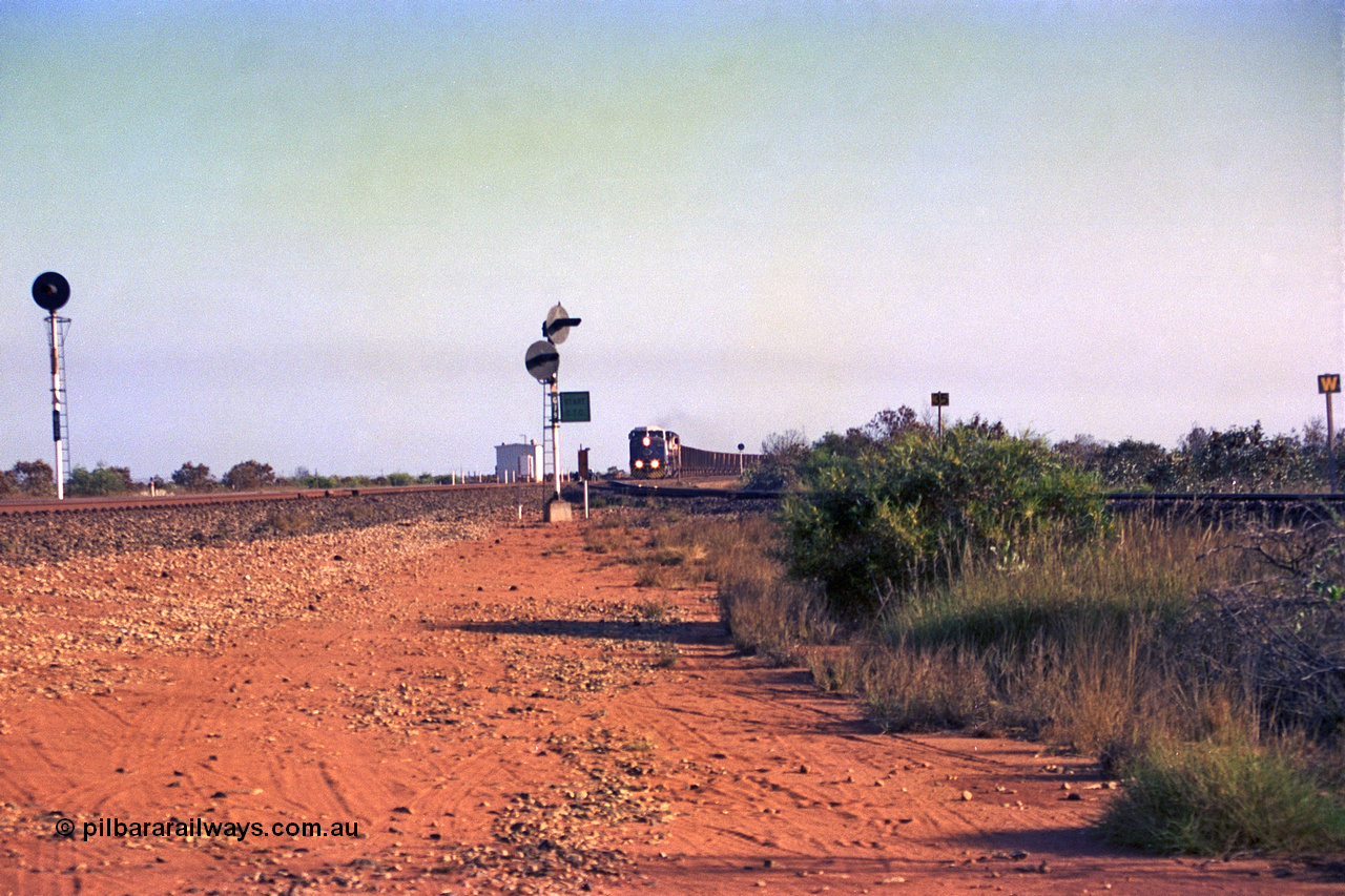 257-29
Goldsworthy Junction looking north as an empty train approaches, the line curving in from the right in the Goldsworthy or Yarrie line. The dual searchlight signal is GJ 9 and is so positioned to allow approaching trains to see the junction signal, like a repeater. Late 2001.
