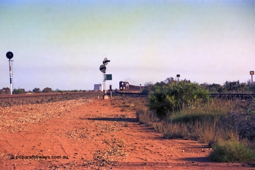 257-29
Goldsworthy Junction looking north as an empty train approaches, the line curving in from the right in the Goldsworthy or Yarrie line. The dual searchlight signal is GJ 9 and is so positioned to allow approaching trains to see the junction signal, like a repeater. Late 2001.

