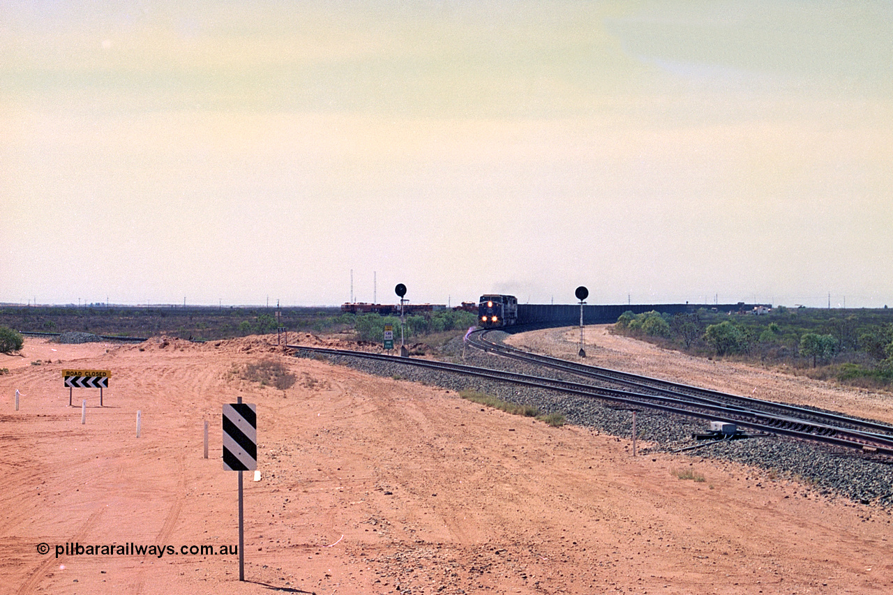 267-02
Goldsworthy Junction, BHP's 1230 empty departure behind General Electric AC6000 unit 6076 'Mt Goldsworthy' serial number 51068 leads CM40-8MEFI 5669 on the point with mid-train units CM40-8M units 5651 and 5645 104 waggons back with 104 waggons trailing. 1247 hrs 12th of April 2002.
Keywords: 6076;GE;AC6000;51068;