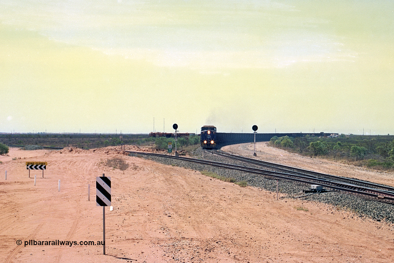 267-04
Goldsworthy Junction, BHP's 1230 empty departure behind General Electric AC6000 unit 6076 'Mt Goldsworthy' serial number 51068 leads CM40-8MEFI 5669 on the point with mid-train units CM40-8M units 5651 and 5645 104 waggons back with 104 waggons trailing. 1247 hrs 12th of April 2002.
Keywords: 6076;GE;AC6000;51068;