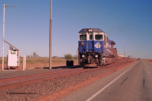 275-12
Boodarie, BHP Iron Ore's 5645 'Sherlock' an Goninan CM40-8M Alco to GE rebuild, departs the service road on its way to Yarrie with an empty, on the left is the Boodarie East interlocking cabinet, the HBI plant is visible and the beneficiation plant to its right. The loaded is running down the mainline towards Finucane Island. This scene has changed immensely since August 10, 2003, there is another line located where the bitumen road is, the HBI is gone and the is a turn wye and fuel roads pretty much behind those shrubs. August 10, 2003.
Keywords: 5645;Goninan;GE;CM40-8M;8281-11/92-134;rebuild;AE-Goodwin;ALCo;M636C;5475;G6047-7;