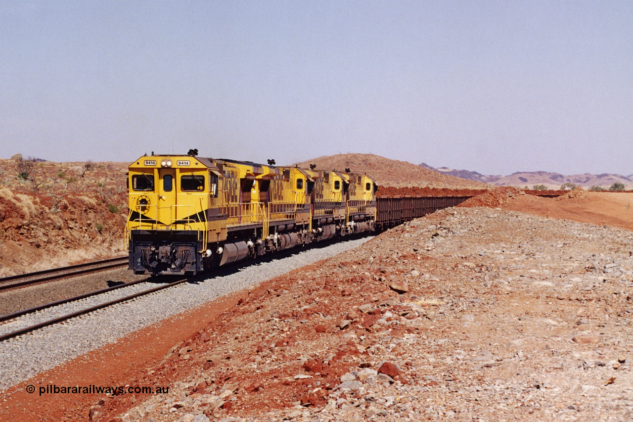 283-19
Harding Siding, quad Robe River CM40-8M units 9414, 9420, 9410 and 9425 lead 202 loaded ore waggons at Siding 1 (Harding). The siding has recently been renamed Harding and extended at the north end to accommodate the new West Angelas trains of up to 240 waggons. Wednesday 22nd May 2002.
Keywords: 9414;Goninan;GE;CM40-8M;8206-11/91-124;rebuild;AE-Goodwin;ALCo;M636;G6060-5;