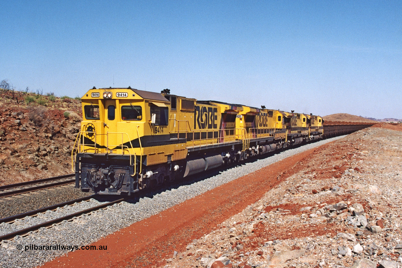 283-21
Harding Siding, quad Robe River CM40-8M units all rebuilt by Goninan from various ALCo models show their tank and bogie differences here. 9414, 9420, 9410 and 9425 lead 202 loaded ore waggons at Siding 1 (Harding). The siding has recently been renamed Harding and extended at the north end to accommodate the new West Angelas trains of up to 240 waggons. Wednesday 22nd May 2002.
Keywords: 9414;Goninan;GE;CM40-8M;8206-11/91-124;rebuild;AE-Goodwin;ALCo;M636;G6060-5;