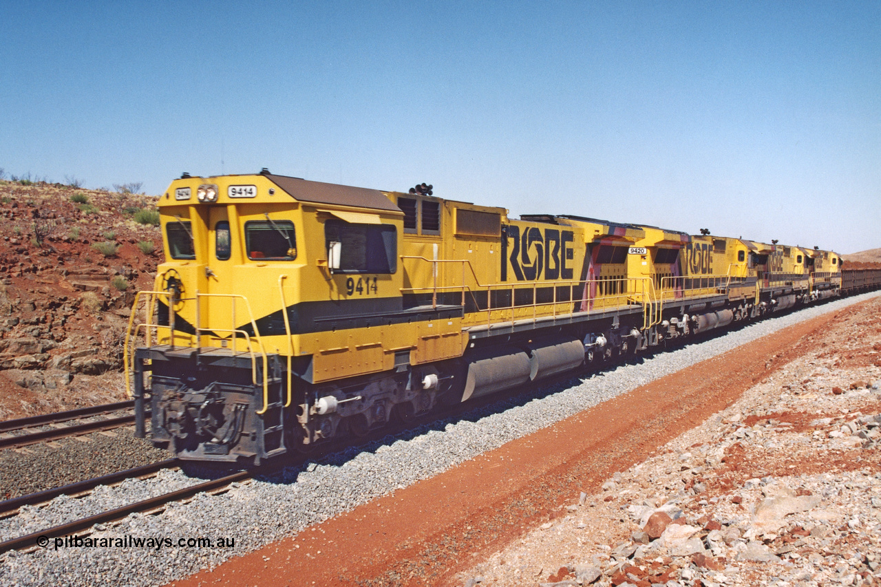 283-22
Harding Siding, quad Robe River CM40-8M units all rebuilt by Goninan from various ALCo models show their tank and bogie differences here. 9414, 9420, 9410 and 9425 lead 202 loaded ore waggons at Siding 1 (Harding). The siding has recently been renamed Harding and extended at the north end to accommodate the new West Angelas trains of up to 240 waggons. Wednesday 22nd May 2002.
Keywords: 9414;Goninan;GE;CM40-8M;8206-11/91-124;rebuild;AE-Goodwin;ALCo;M636;G6060-5;