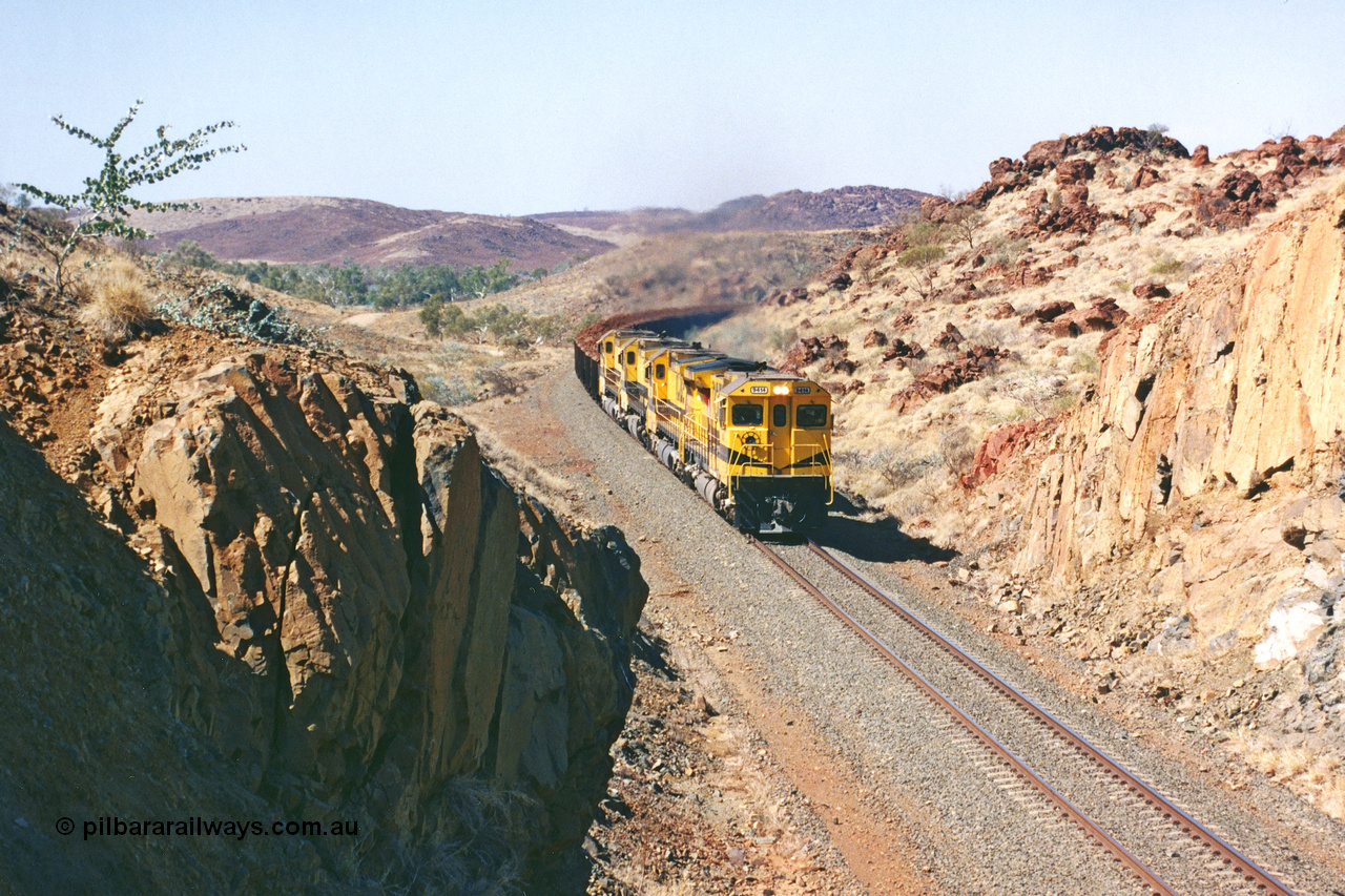 283-31
Near Woodbrook as quad Robe River CM40-8M units 9414, 9420, 9410 and 9525 work a loaded 202 waggons bound for Cape Lambert as they power through the cutting up a short grade at the 37.5 km pipe bridge. 9414 with serial number 8206-11 / 91-124 was rebuilt by Goninan in 1991 from AE Goodwin built M636 ALCo model with original serial number G-6060-5 from 1971. 22nd of May 2002.
Keywords: 9414;Goninan;GE;CM40-8M;8206-11/91-124;rebuild;AE-Goodwin;ALCo;M636;G6060-5;