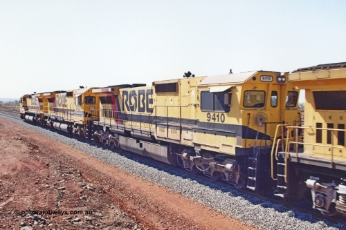 283-25
Harding Siding, Robe River locomotive 9410 which is a Goninan WA ALCo to GE rebuild CM40-8M with serial 2160-03 / 96-202 from March 1996 riding on Dofasco bogies and was originally a Comeng NSW built M636 ALCo serial C-6096-5 and built new for Mt Newman Mining (later BHP Iron Ore) in November 1975 and numbered 5500. Everything below the frame is ALCo, with the Comeng build style flat fuel tank, while above is GE and Pilbara Cab. May 22, 2002.
Keywords: 9410;Goninan;GE;CM40-8M;2160-03/96-202;rebuild;Comeng-NSW;ALCo;M636;C-6096-5;