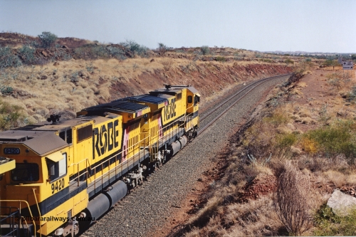 283-34
Near Woodbrook as quad Robe River CM40-8M units 9414, 9420, 9410 and 9525 work a loaded 202 waggons bound for Cape Lambert as they pass through the cutting at the 37.5 km pipe bridge. 9420 which is a Goninan WA ALCo to GE rebuild CM40-8M with serial 8109-03 / 91-119 from March 1991 riding on Hi-Ad bogies and was originally an ALCo Schenectady built C630 serial 3486-4 and built new for Chesapeake & Ohio (USA) as their 2103. It is one of four C630 ALCo units purchased in 1974 and delivered to Robe in January 1975. Everything below the frame is ALCo while above is GE and Pilbara Cab. 22nd May 2002.
Keywords: 9420;Goninan;GE;CM40-8M;8109-03/91-119;rebuild;ALCo;C630;3486-4;C+O;2103;