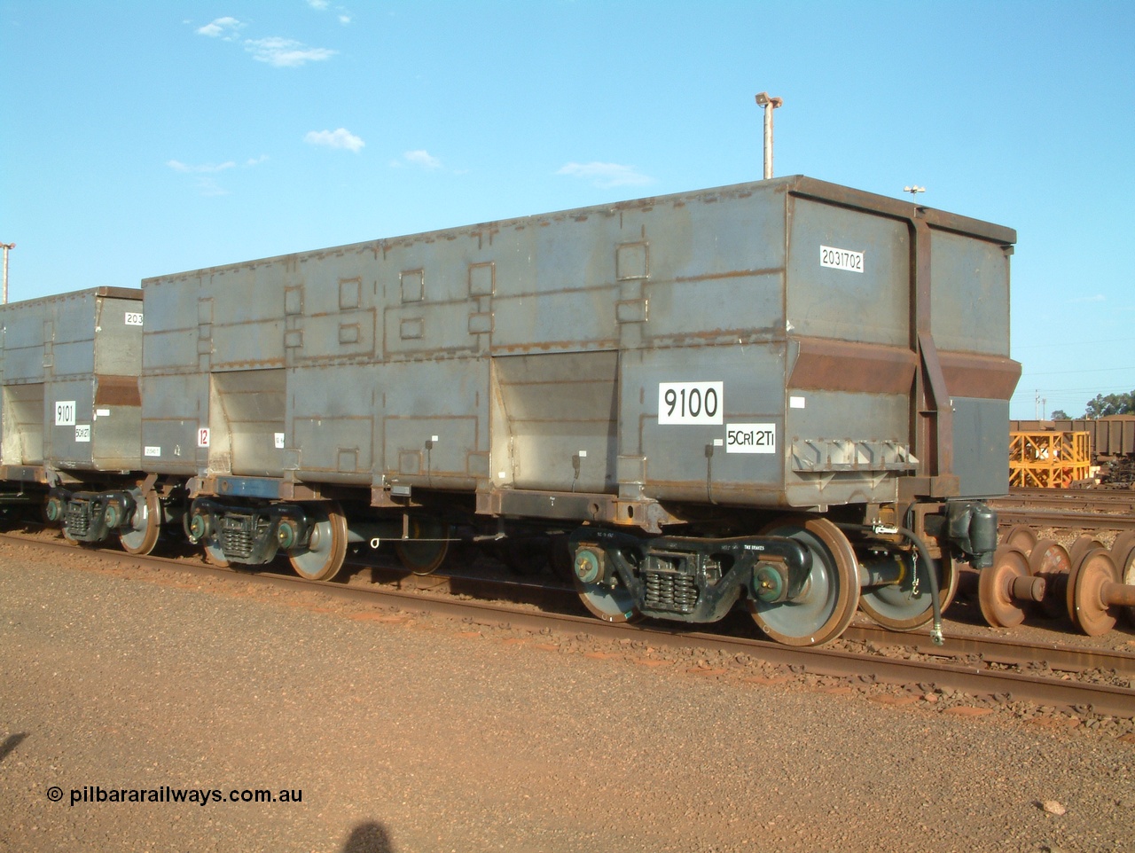 041225 064541
Nelson Point Ore Car Repair Shops, brand new Bradken NSW built ore waggon and type leader 9100 asset number 2031702 and 9101 behind it. These waggons are the latest additions to the fleet with 20 on order in total. They are made from the same 5Cr12Ti steel that the Goninan Golynx waggons are made. 9100 has been set up for use as a 'test' waggon with load sensors located all over it. 25th December 2004.
Keywords: 9100;Bradken-NSW;BHP-ore-waggon;