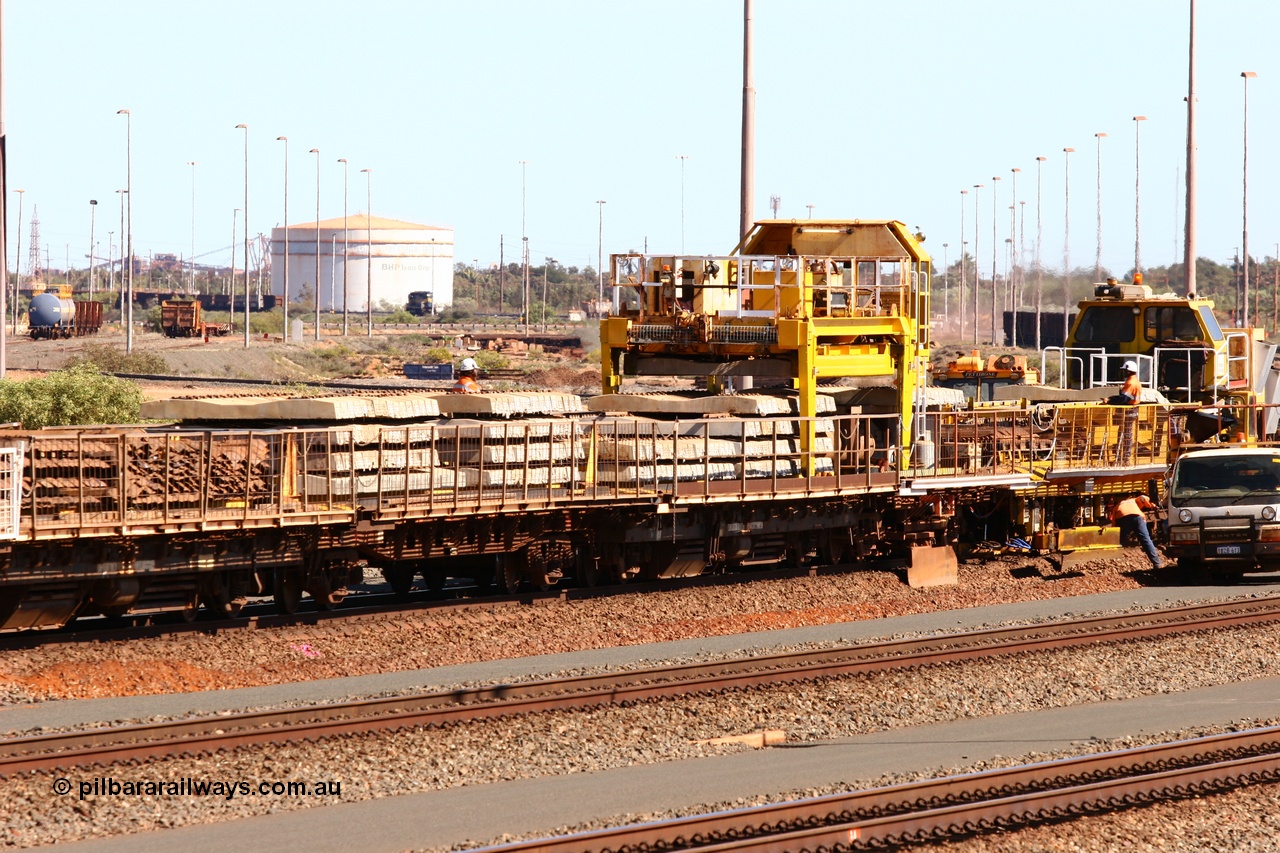 050724 4234
Nelson Point yard, flat waggons in service on the Pony re-laying train as transport waggons for sleepers, with a gantry car delivering concrete sleepers to replace the removed steel sleepers. The middle waggon is an ex Goldsworthy Mining flat waggon with a Scotts of Ipswich built flat either side, built in 1970 for then Mt Newman Mining Company.
Keywords: Scotts-Qld;BHP-pony-waggon;