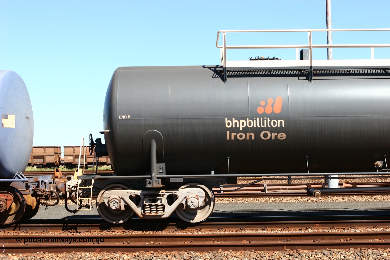 060414 3458
Nelson Point yard, empty fuel tank waggon 0015, view of B end and bogie, a Comeng WA built 116 kilolitre tank waggon, one of a batch of six built in 1974-75 wearing the newer corporate 'Earth' livery of BHP Billiton Iron Ore.
Keywords: Comeng-WA;BHP-tank-waggon;