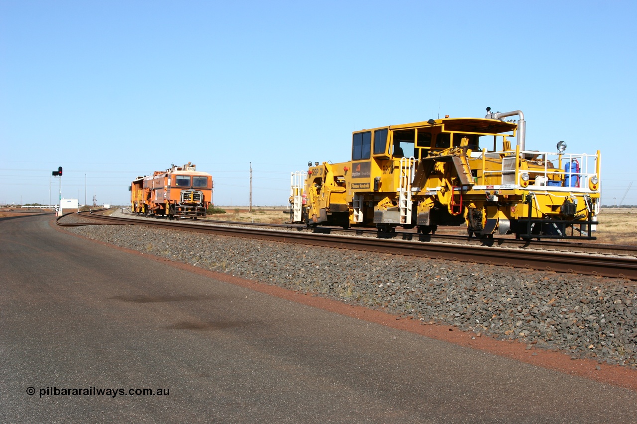 060710 6235
At the Broome Rd grade crossing Port Hedland, track machine BR 33 a Plasser Australia ballast regulator model SSP 302 serial M486 follows Plasser Australia Unimat S4 switch tamper SW 02 as the head south. 10th July 2006.
Keywords: track-machine;