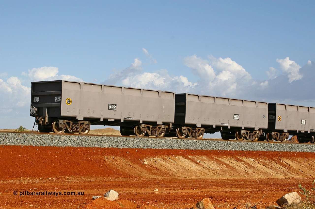 080116 1364
Chapman Siding at the 69 km on FMG's under construction line to Cloud Break mine, new waggons stabled in the passing track awaiting service, built by China Southern or CSR at their Zhuzhou Rolling Stock Works in China in 2007, here slave waggon 1395 and master waggon 2396 sit in the arvo sunlight. The yellow circle indicates the rotary coupler end and the tare weight of the slave waggon at 22.6 tonnes, while the master weighs 22.9 tonnes as it hosts the brake control equipment. 16th January 2008. 
Keywords: 1395-2396;CSR-Zhuzhou-Rolling-Stock-Works-China;FMG-ore-waggon;