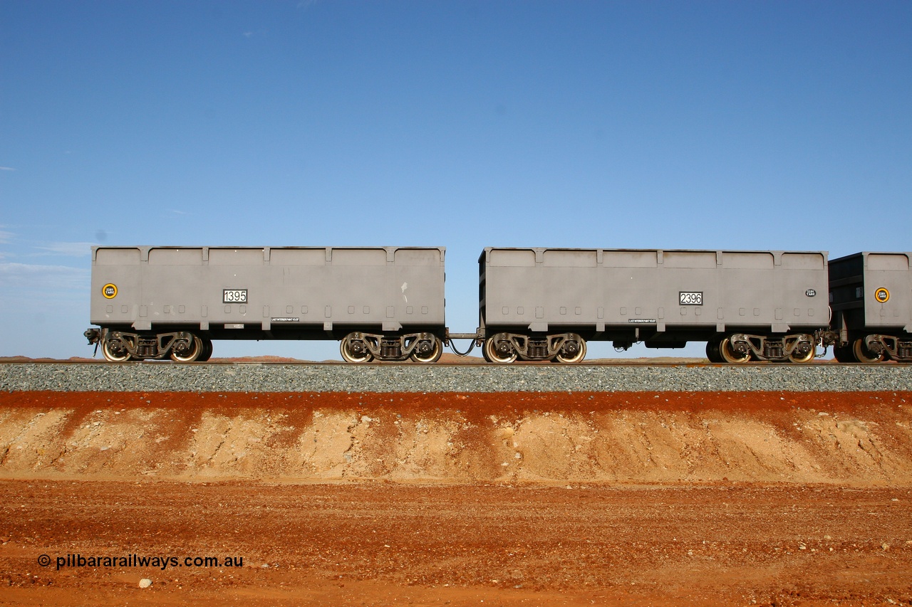 080116 1365
Chapman Siding at the 69 km on FMG's under construction line to Cloud Break mine, new waggons stabled in the passing track awaiting service, built by China Southern or CSR at their Zhuzhou Rolling Stock Works in China in 2007, here slave waggon 1395 and master waggon 2396 sit in the arvo sunlight. The yellow circle indicates the rotary coupler end and the tare weight of the slave waggon at 22.6 tonnes, while the master weighs 22.9 tonnes as it hosts the brake control equipment. 16th January 2008. 
Keywords: 1395-2396;CSR-Zhuzhou-Rolling-Stock-Works-China;FMG-ore-waggon;