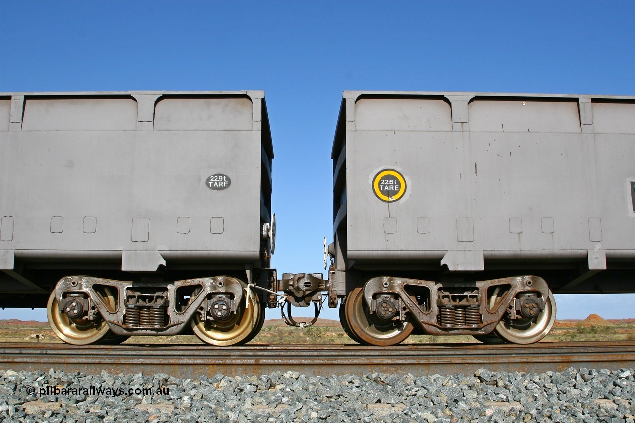 080116 1375
Chapman Siding, view of FMG's CSR Zhuzhou Rolling Stock Works built waggons showing the 'F' type Interlock fixed and rotary couplers between master waggon 2396 and slave waggon 1187. Note the difference in the tare weights, 2396 with the fixed coupler is the master waggon, while 1187 is the slave waggon with the rotary coupler. The yellow circle also denotes the rotary coupler end. 16th January 2008.
Keywords: 2396;CSR-Zhuzhou-Rolling-Stock-Works-China;FMG-ore-waggon;