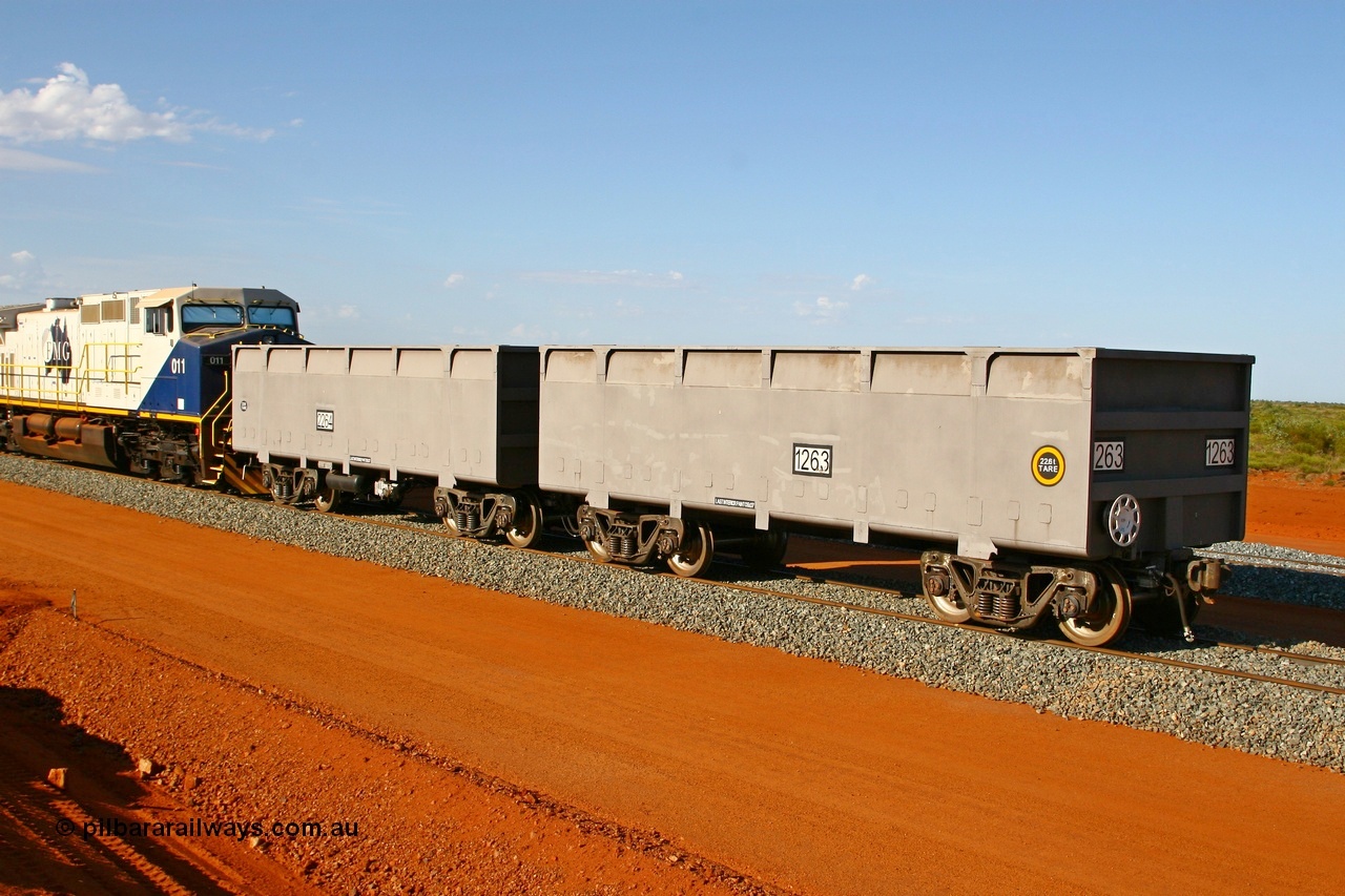 080120 1469
Thomas Yard, new FMG ore waggon pair 1263 slave and 2264 control waggons, 22.6 tonnes tare with rotary coupler, and the master at 22.9 tonnes. View from the handbrake end coupled to a GE Dash 9-44CW unit 011. 20th January 2008.
Keywords: 1263-2264;CSR-Zhuzhou-Rolling-Stock-Works-China;FMG-ore-waggon;