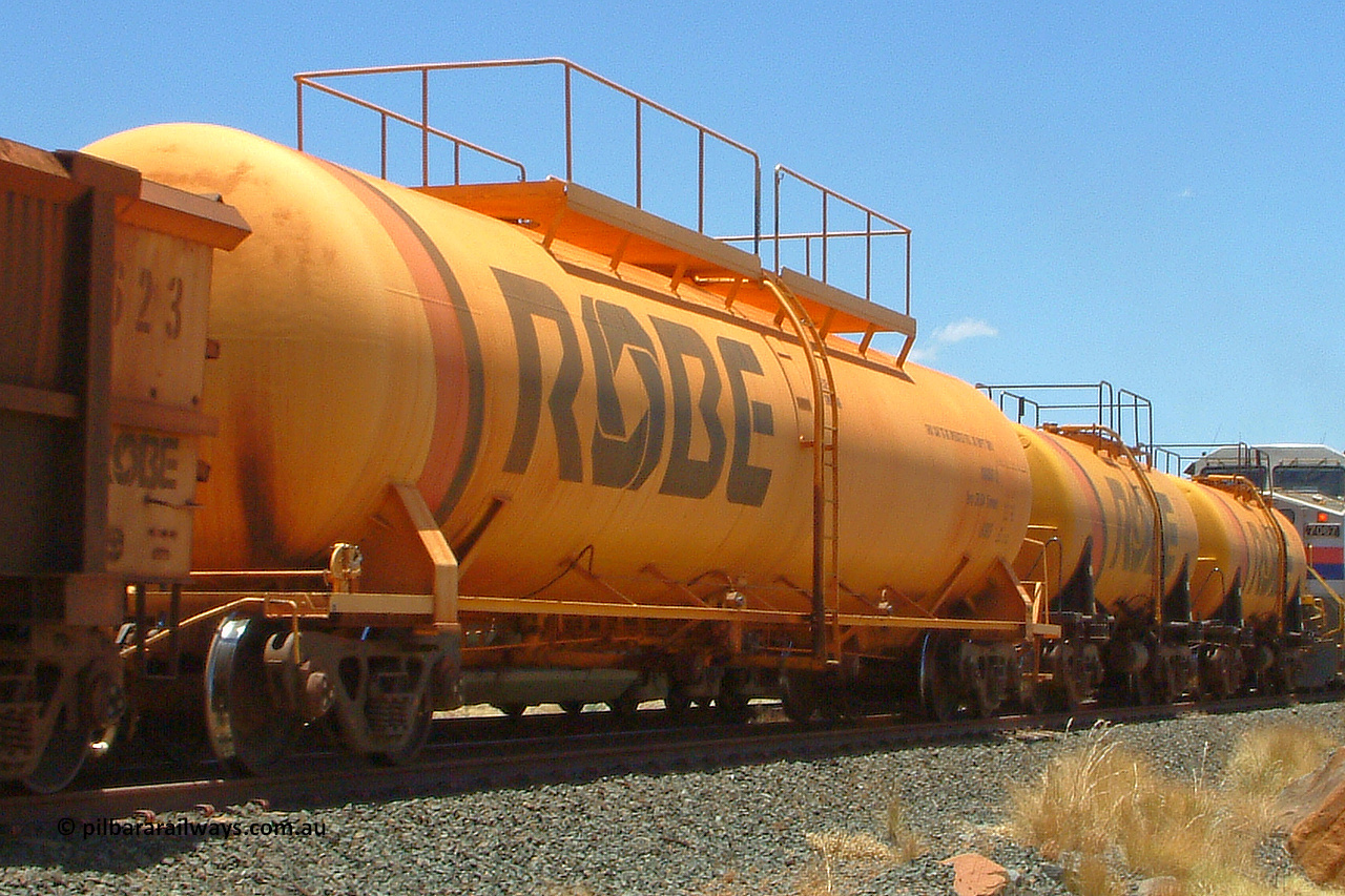 8003 050110 122348
Maitland Siding [Sinding Two], Robe River diesel fuel tank waggon 8003 running loaded on an empty ore train, built by Comeng NSW in March 1979 with a 100,000 litre capacity. 1223 hours, January 10, 2005.
Keywords: 8003;Comeng-NSW;Robe-tank-waggon;
