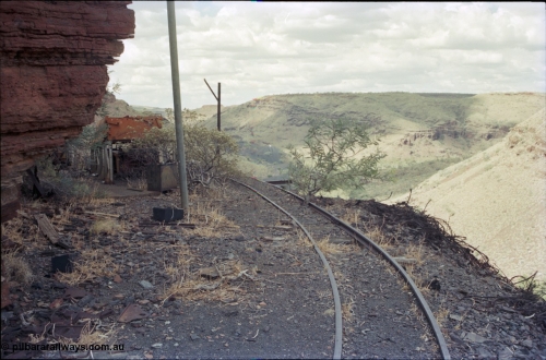194-16
Wittenoom Gorge, Colonial Mine, asbestos mining remains, view looking north east from storage roads with tracking heading back around to workshops, battery module box visible on ramp.

