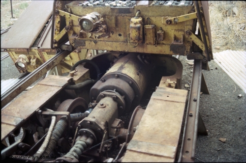 194-23
Wittenoom, Colonial Mine, asbestos mining remains, detail view of Mancha battery locomotive with battery module sitting off loco, shows drive shaft to front axle from rear axle gearbox and wheels and large traction motor at the rear, on the battery module are the head light and cover hinge arrangement.
